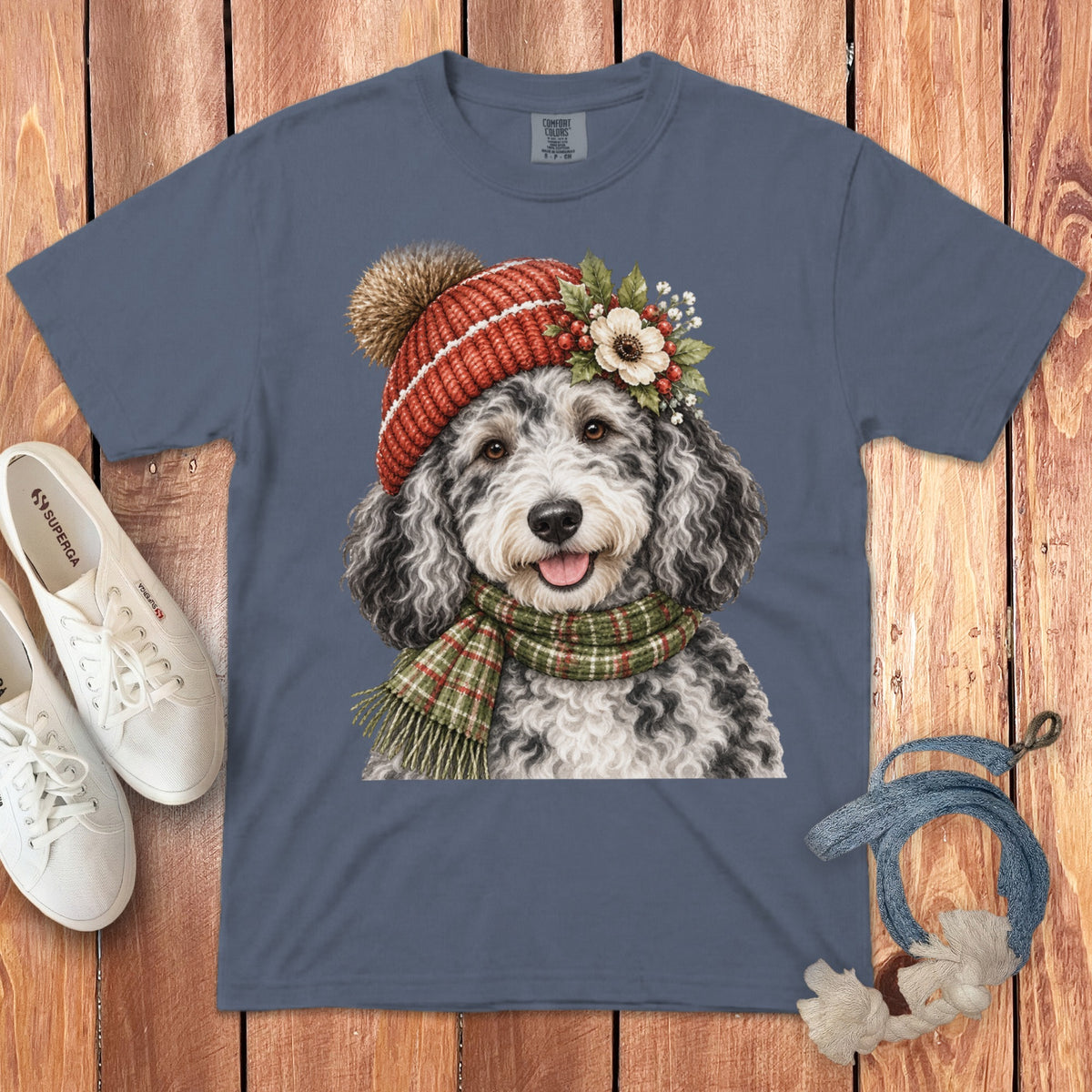 T-shirt with watercolor art of a fluffy dog wearing a red beanie and plaid scarf.