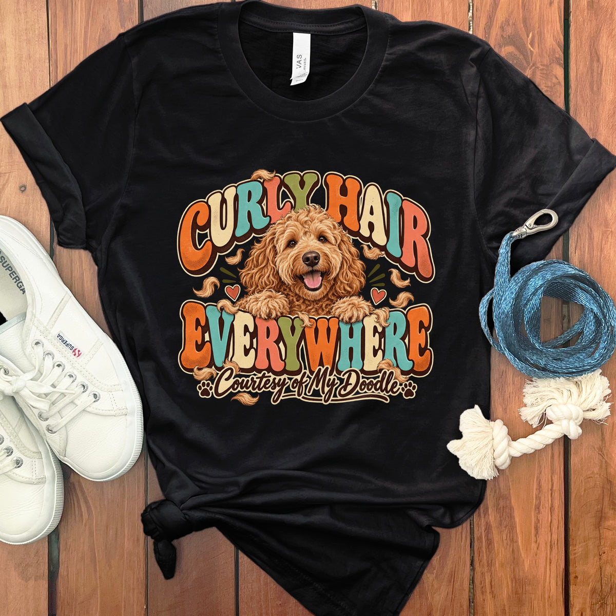 Black t-shirt with a goldendoodle and text "Curly Hair Everywhere Courtesy of My Doodle."