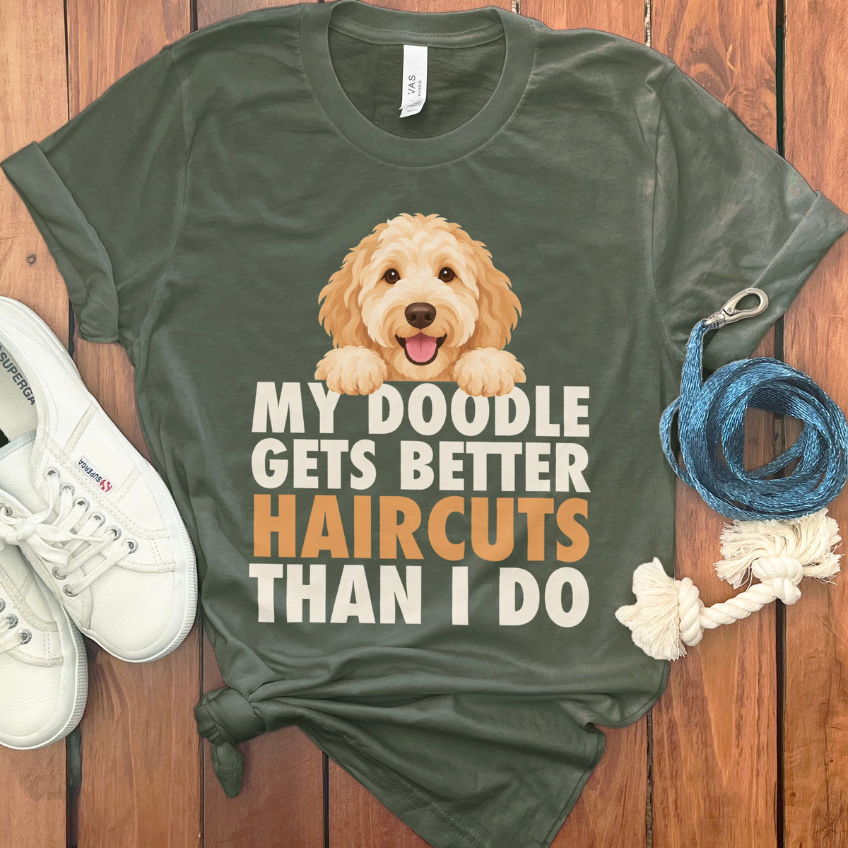 Green t-shirt with a goldendoodle and text "MY DOODLE GETS BETTER HAIRCUTS THAN I DO".