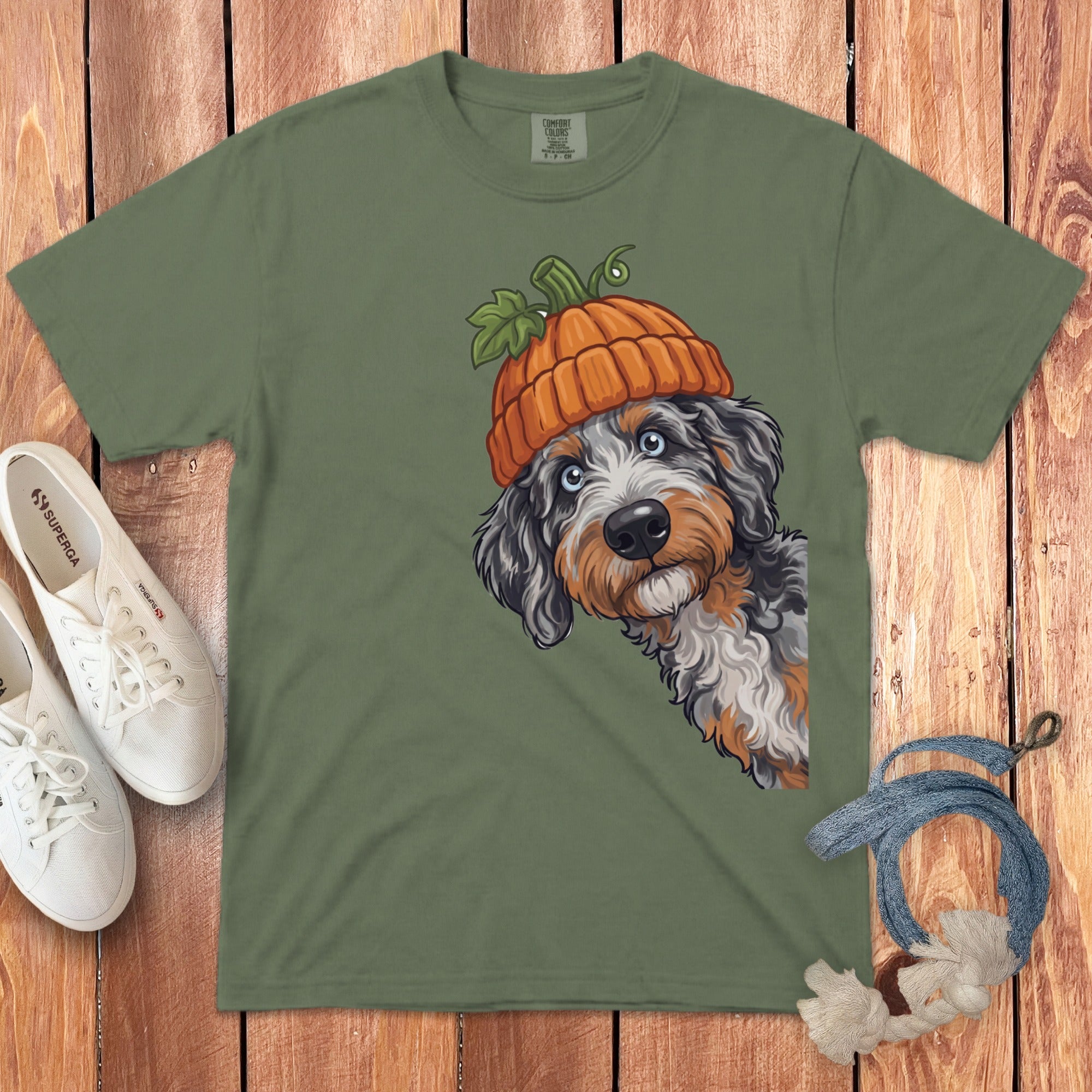 Green t-shirt with illustration of dog wearing pumpkin hat and white sneakers