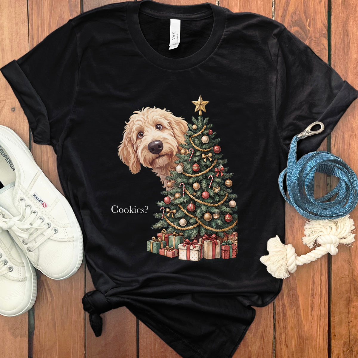 Black t-shirt with a doodle dog peeking from behind a decorated Christmas tree.