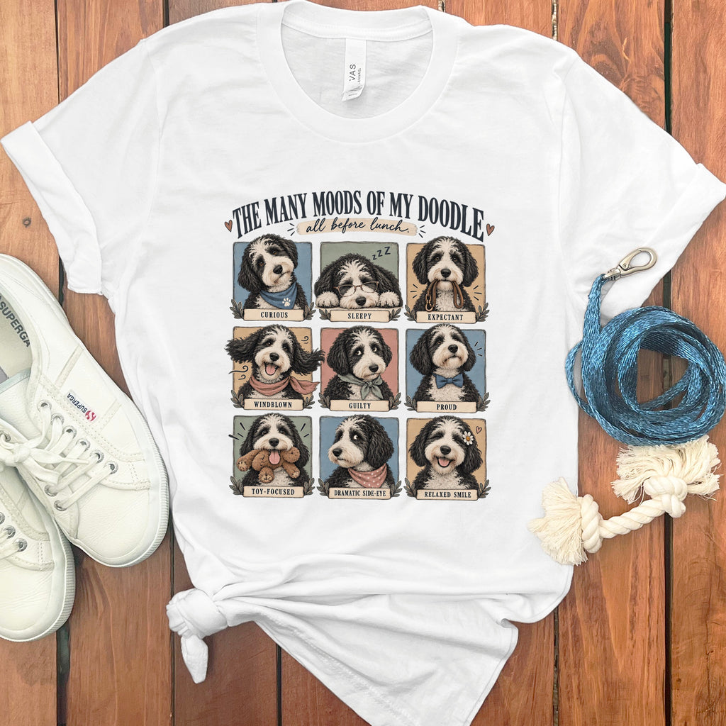 White t-shirt graphic with nine doodle dog portraits titled "The Many Moods of My Doodle."