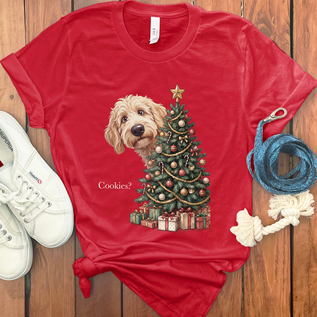 Red t-shirt with doodle dog peeking from behind a decorated Christmas tree and presents, text "Cookies?".