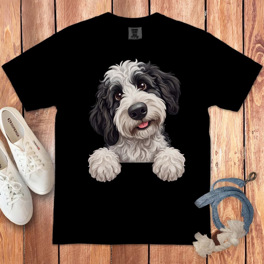 Black t-shirt with a white and black dog illustration peeking over the top.
