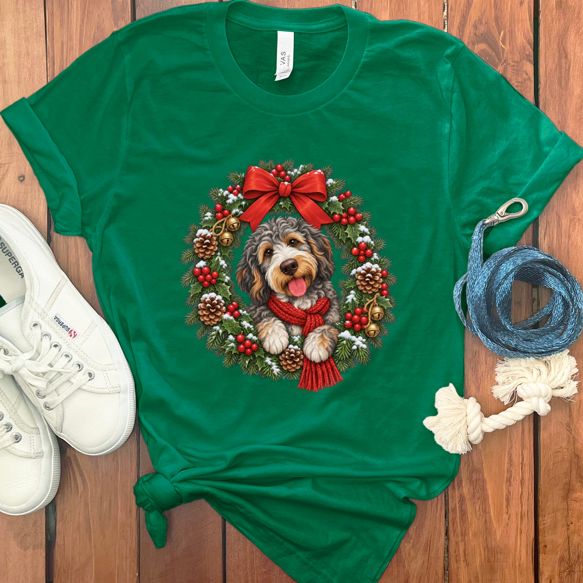 A green t-shirt features a graphic of a fluffy dog inside a Christmas wreath.