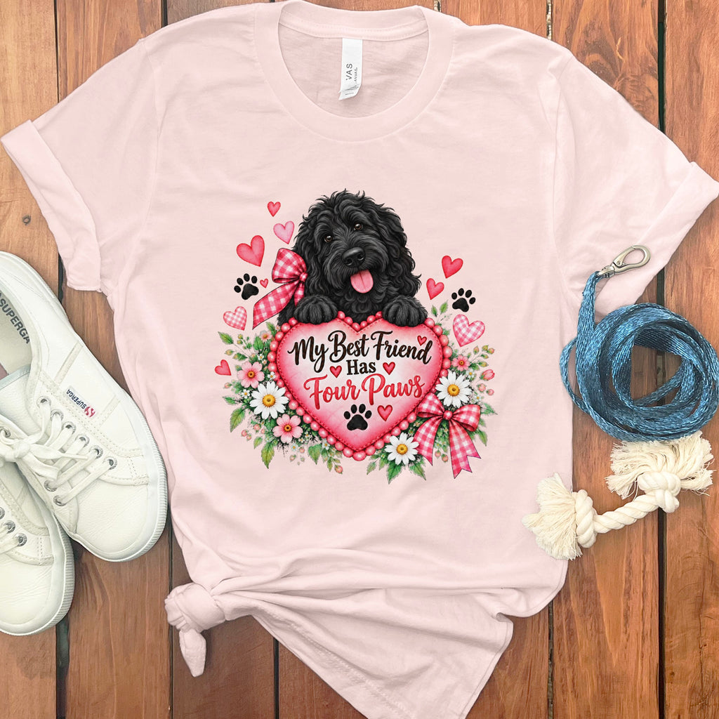 A light pink t-shirt features a graphic of a black dog holding a heart with text reading, My Best Friend Has Four Paws, surrounded by flowers and floating hearts.