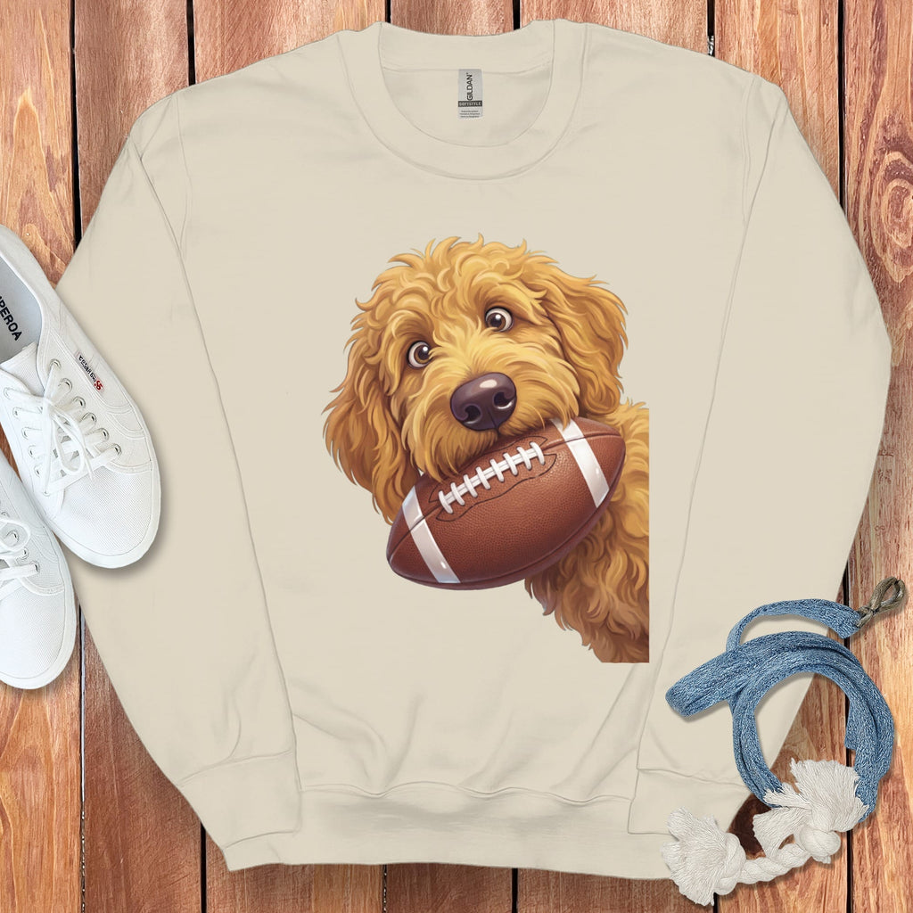 Cream sweatshirt with a cartoon goldendoodle dog holding a football.