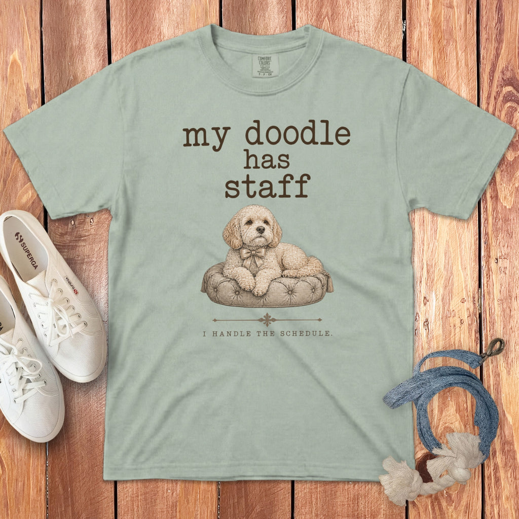 Light green t-shirt with "my doodle has staff I HANDLE THE SCHEDULE." text and illustration of a dog.