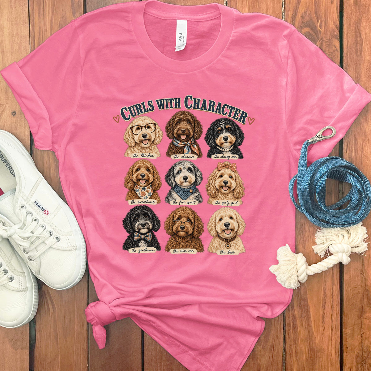 Pink t-shirt with nine doodle dogs in a grid, titled "Curls With Character".