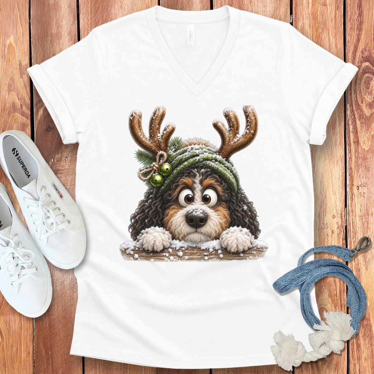 White t-shirt with a cartoon dog wearing reindeer antlers and a green beanie.