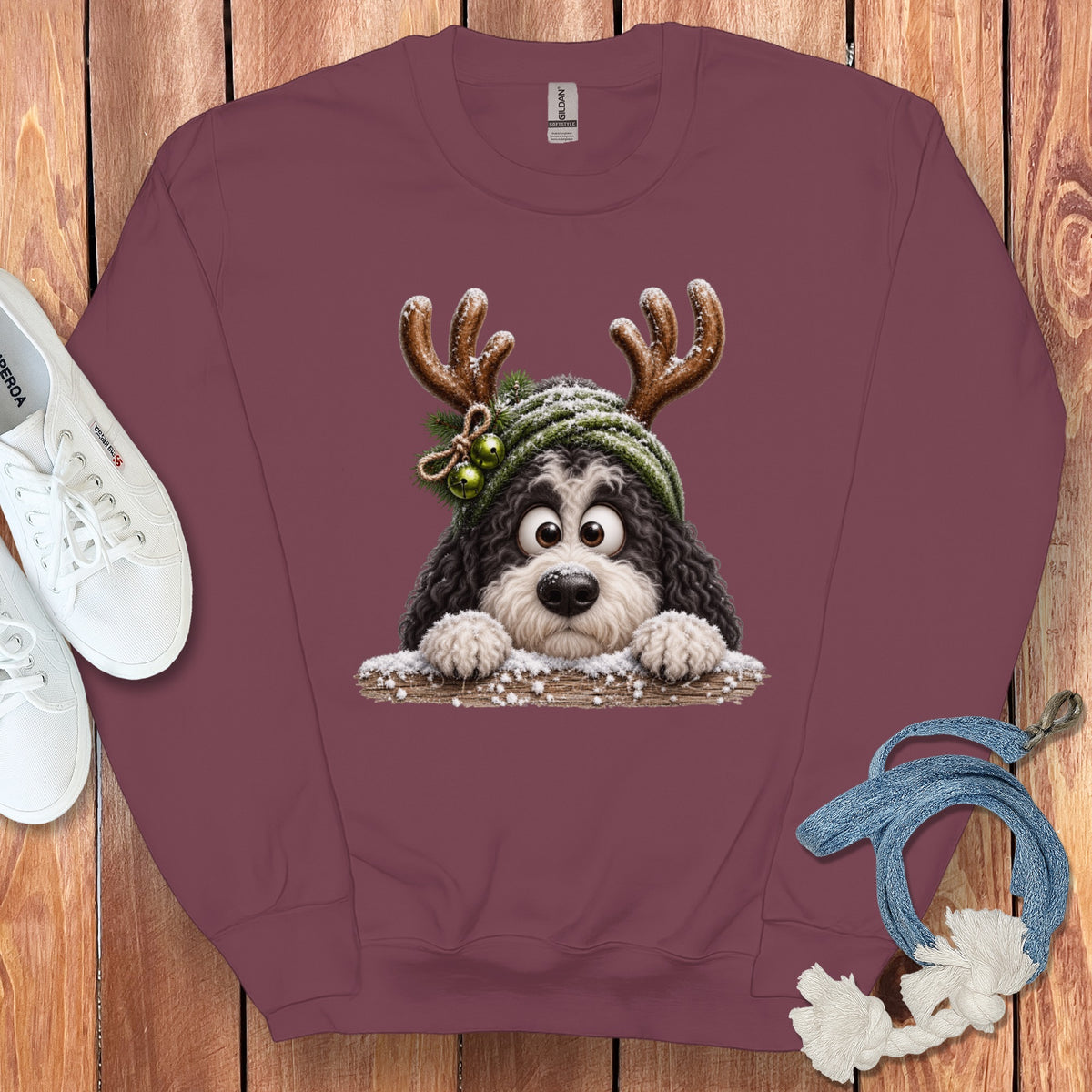 Maroon sweatshirt with a cartoon dog wearing antlers and a green beanie with bells.