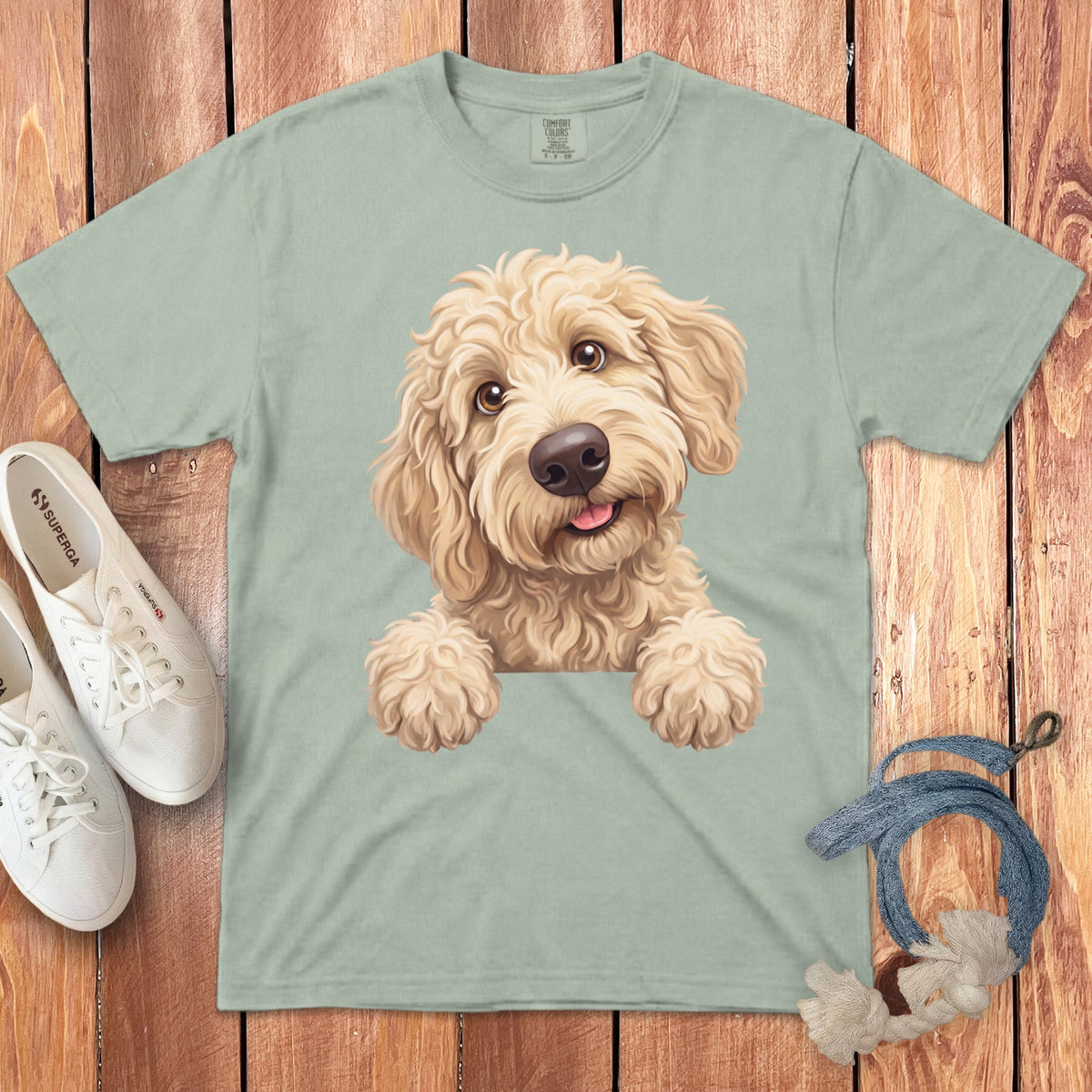 Light sage t-shirt with a cute doodle dog graphic, white Superga sneakers, and dog toy.