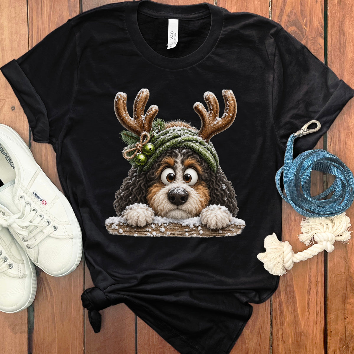 Black t-shirt with fluffy dog wearing reindeer antlers and festive hat.
