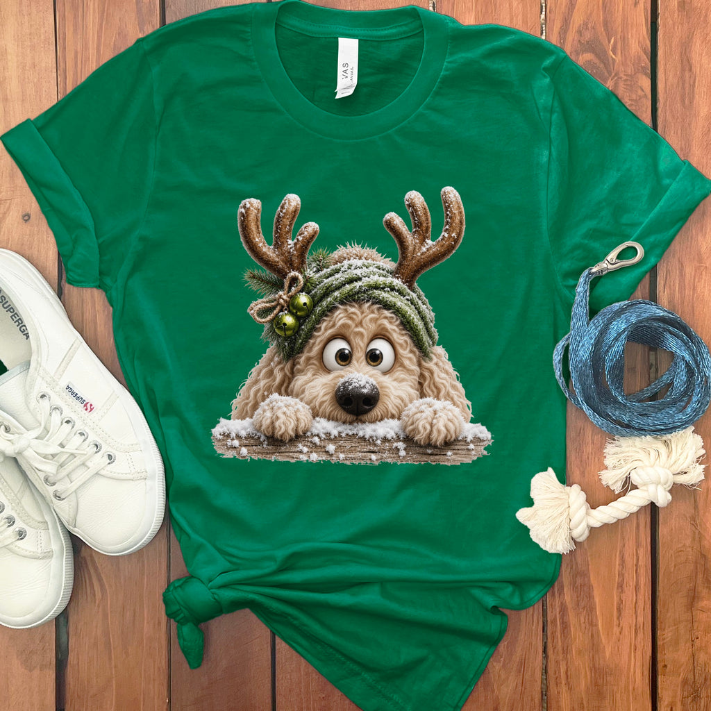 Green t-shirt with a fluffy dog wearing antlers and a beanie peeking over snow.