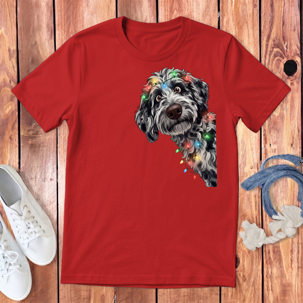 Red t-shirt with a black and white doodle dog wearing colorful Christmas lights.