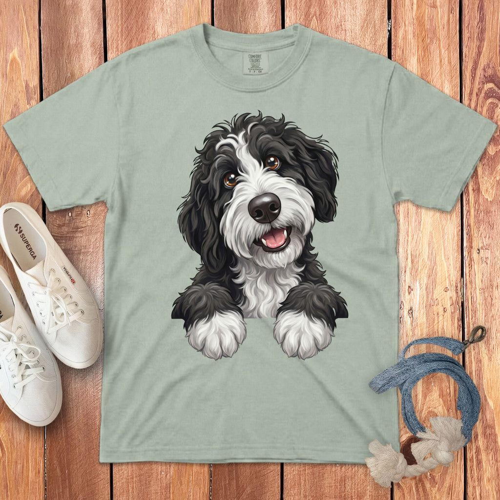 A black and white dog illustration is printed on a light green t-shirt.
