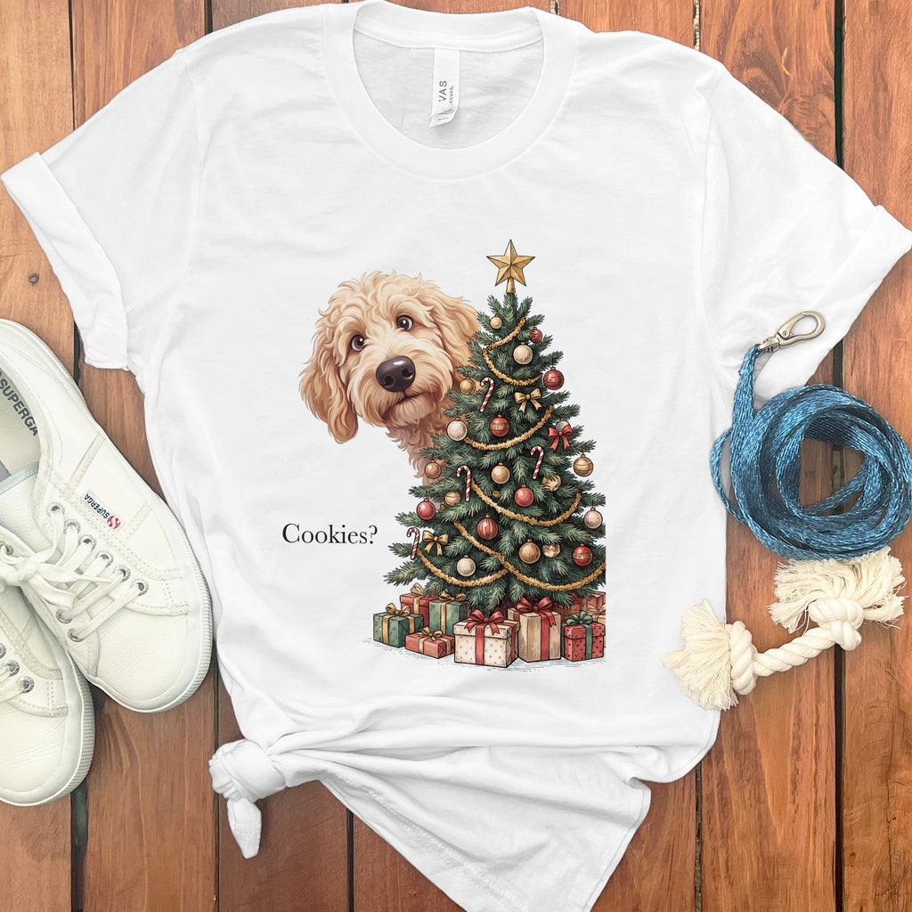 White t-shirt with a doodle dog peeking from behind a Christmas tree and gifts.