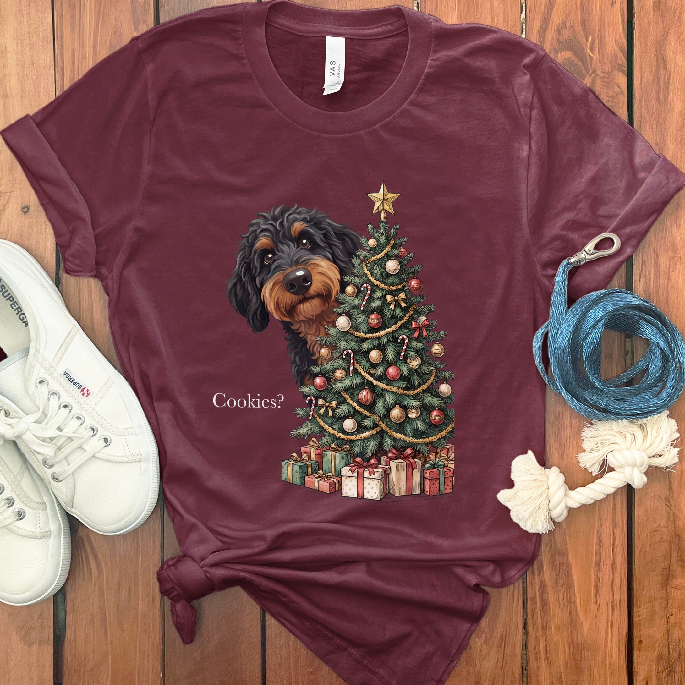 T-shirt with dachshund peeking behind Christmas tree and presents, reads "Cookies?".