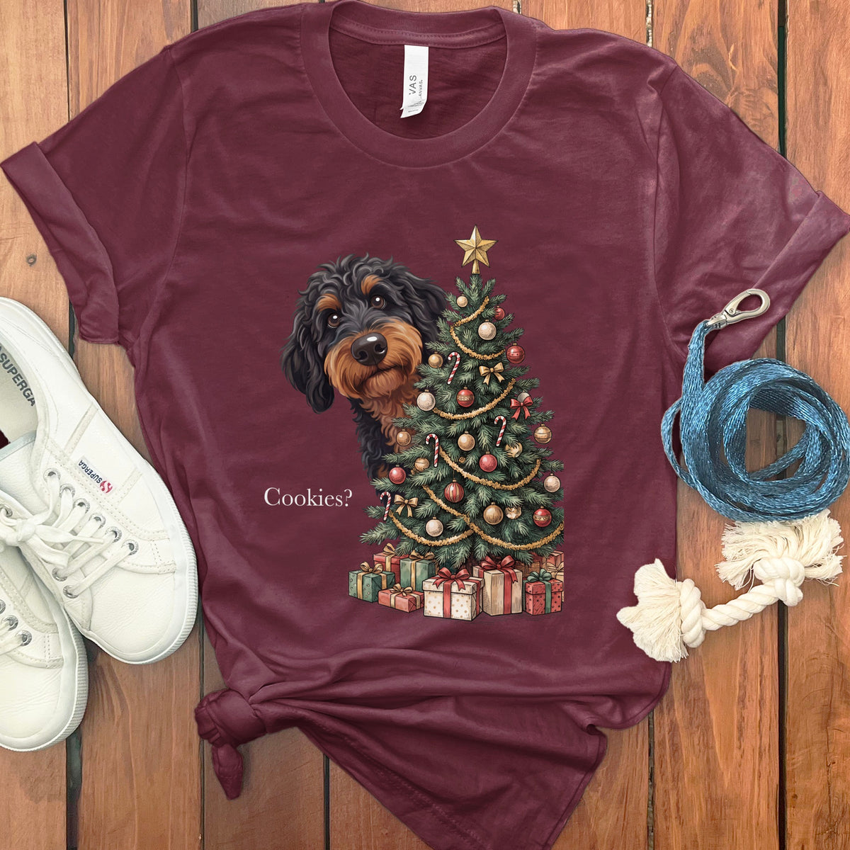 T-shirt with dachshund peeking behind Christmas tree and presents, reads "Cookies?".