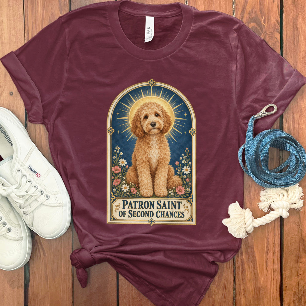 Maroon t-shirt with a framed illustration of a goldendoodle dog, "Patron Saint of Second Chances."