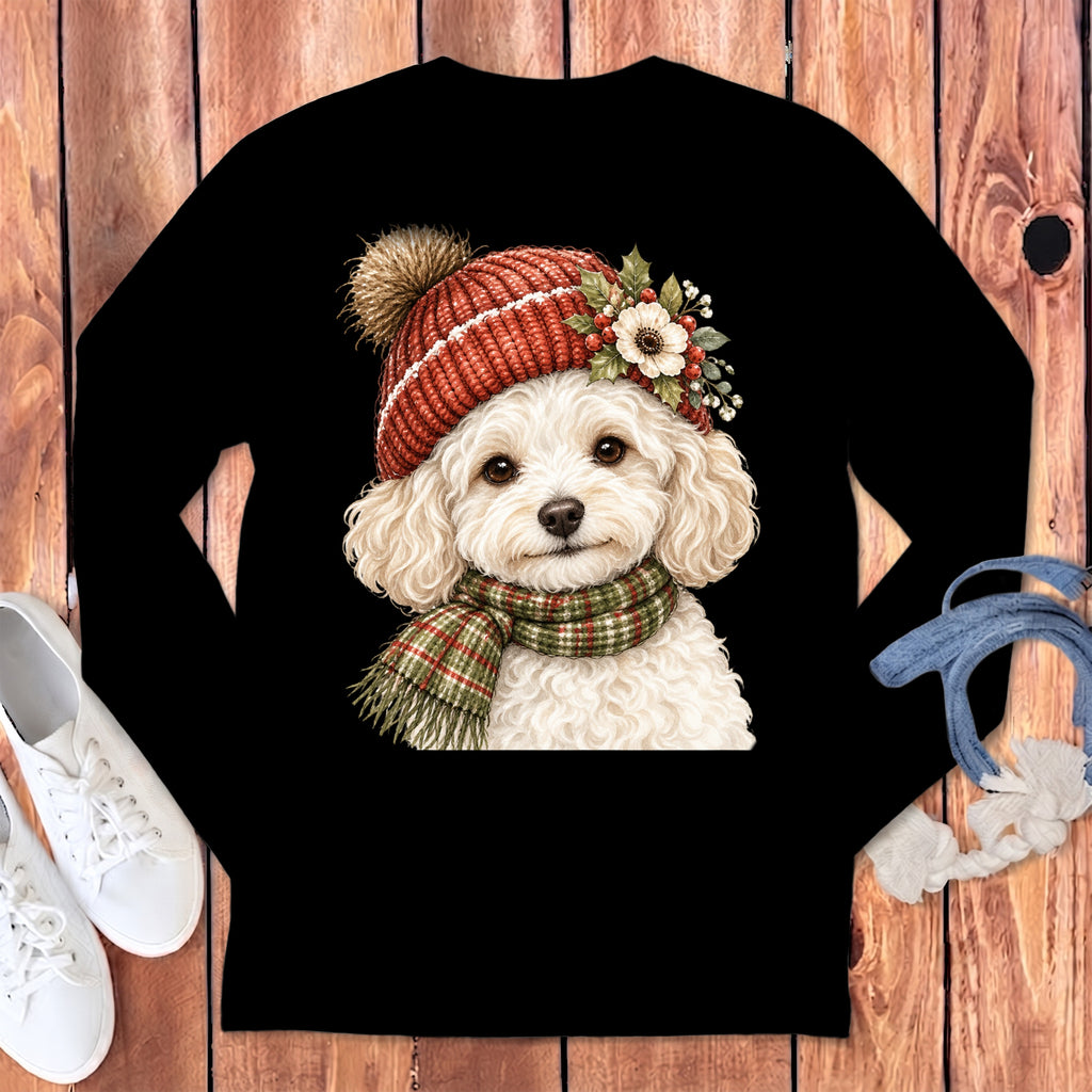 White poodle wearing a red knitted beanie and a plaid scarf with a festive floral accent.