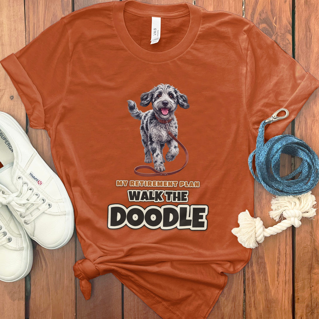 Orange t-shirt with a doodle dog graphic and text reading "My Retirement Plan Walk The Doodle."