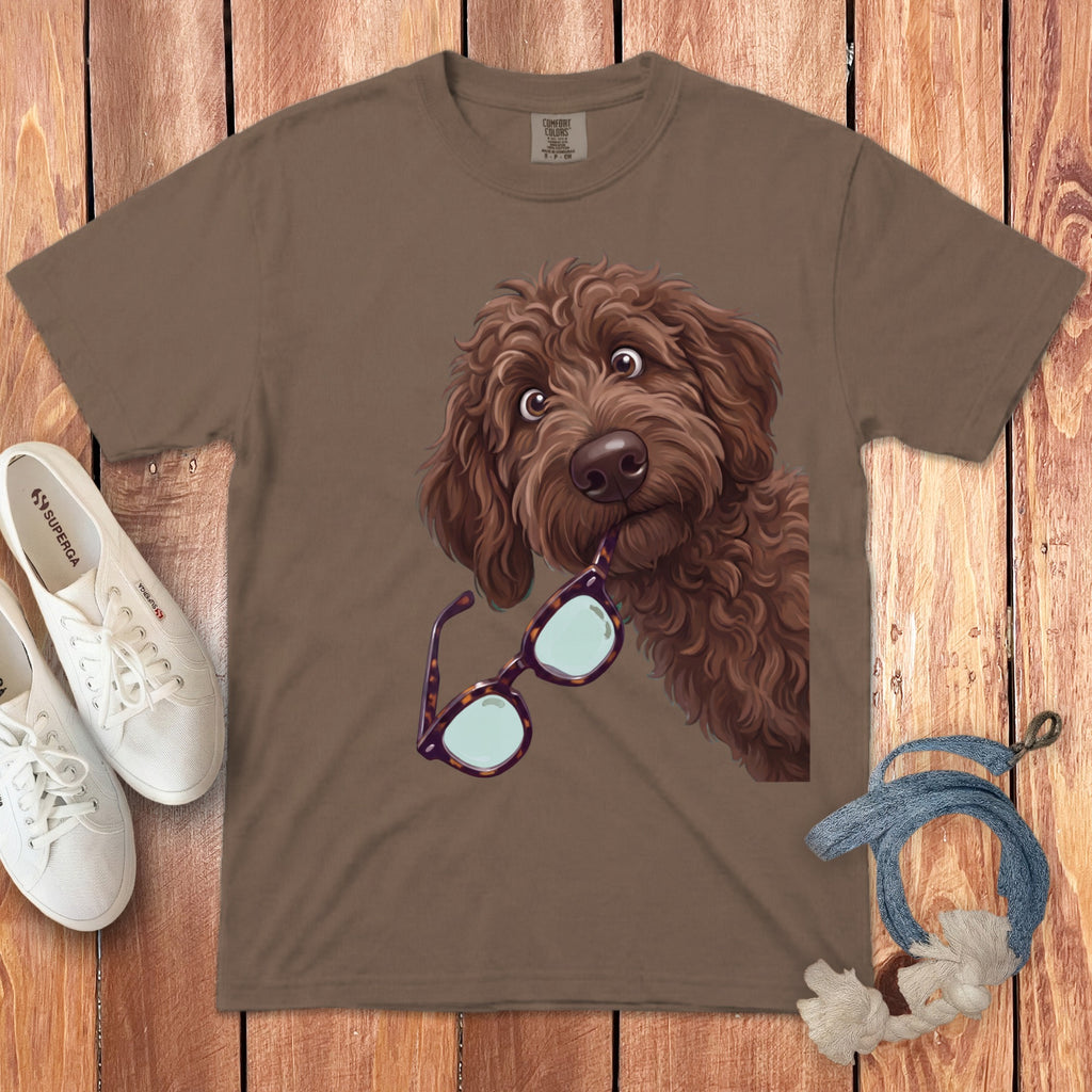 Brown t-shirt featuring an illustration of a brown doodle dog holding tortoiseshell glasses in its mouth.