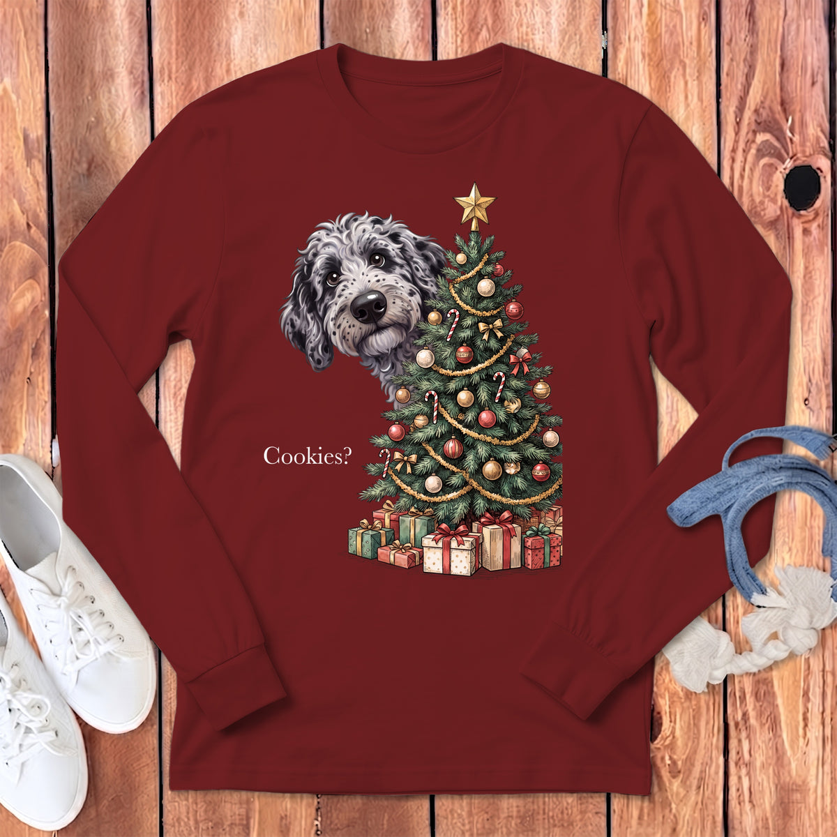 Maroon long-sleeve shirt with a doodle peeking from behind a Christmas tree.