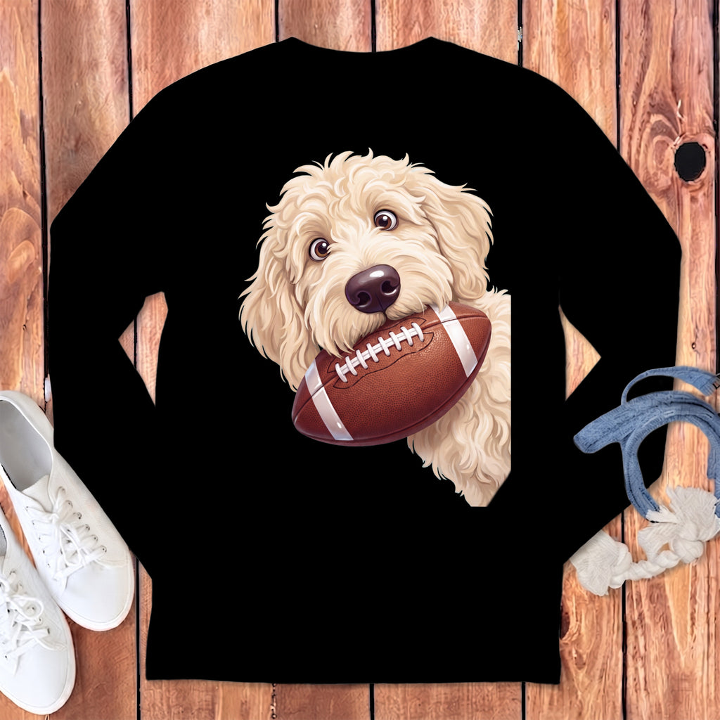 Cream-colored doodle dog holding a brown football in its mouth.