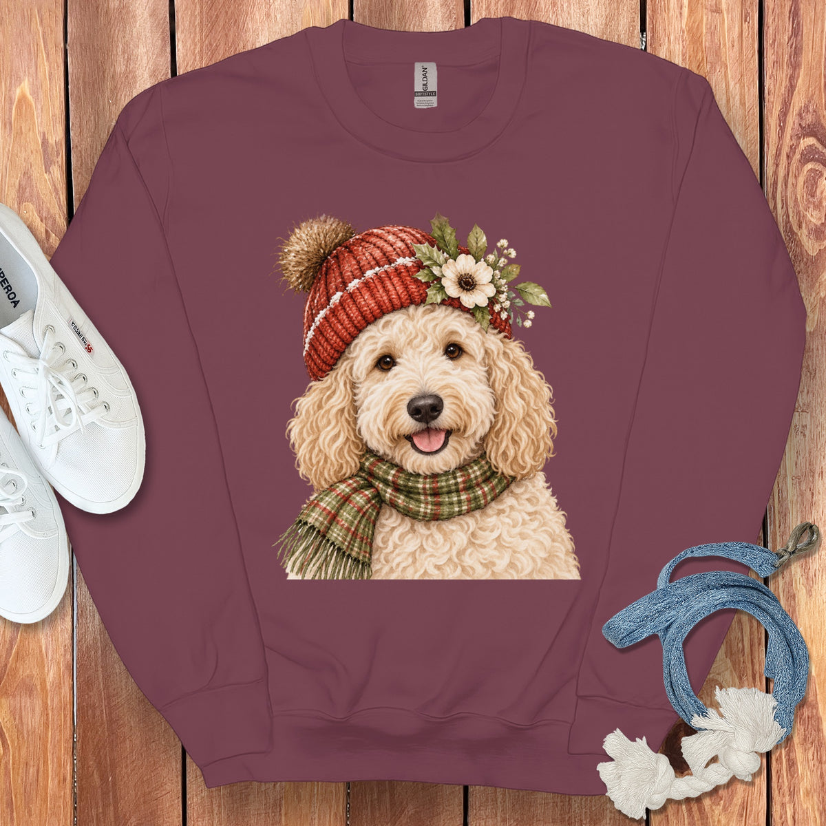 Burgundy sweatshirt with watercolor doodle dog wearing a red pom-pom hat and scarf.