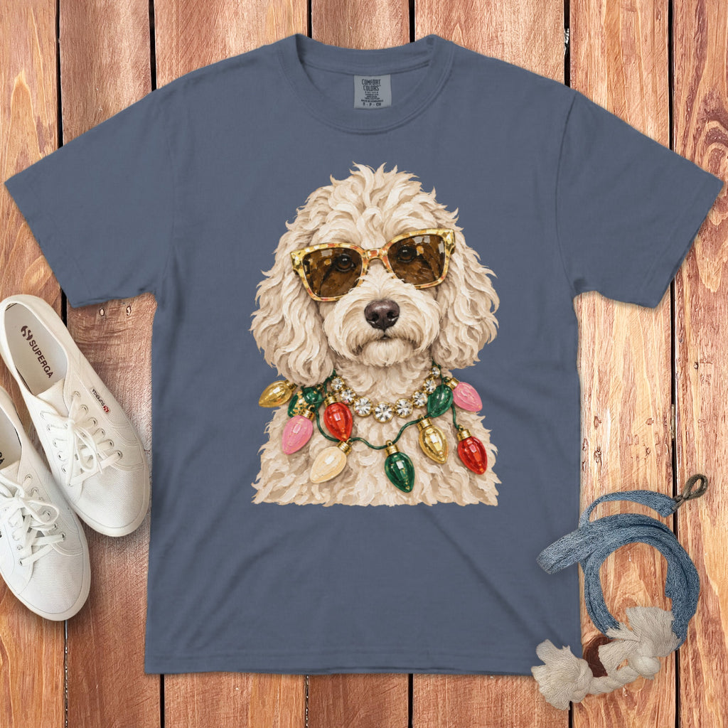 Labradoodle wearing sunglasses and a Christmas lights necklace on a blue t-shirt.