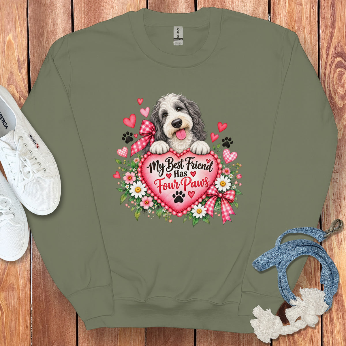 Olive green crewneck sweatshirt featuring a graphic of a fluffy dog resting on a pink heart.