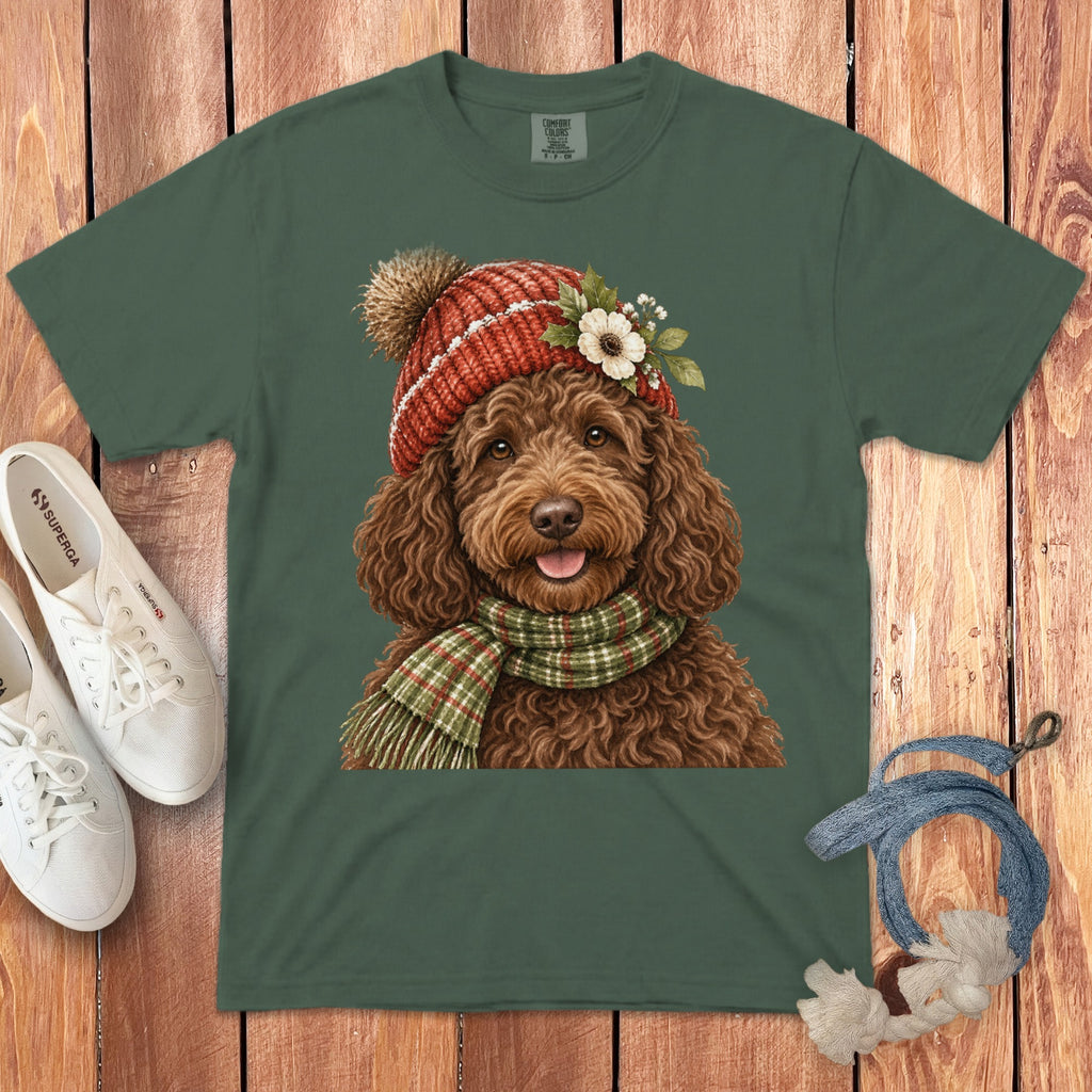 Green t-shirt with a brown doodle dog wearing a red knit hat and plaid scarf.