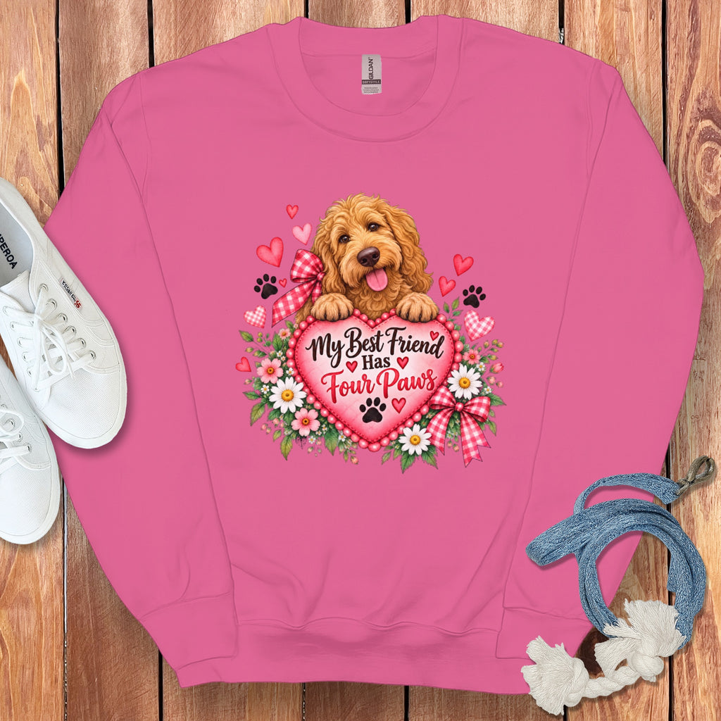 Pink crewneck sweatshirt featuring a graphic of a golden doodle, hearts, flowers, and text reading My Best Friend Has Four Paws.