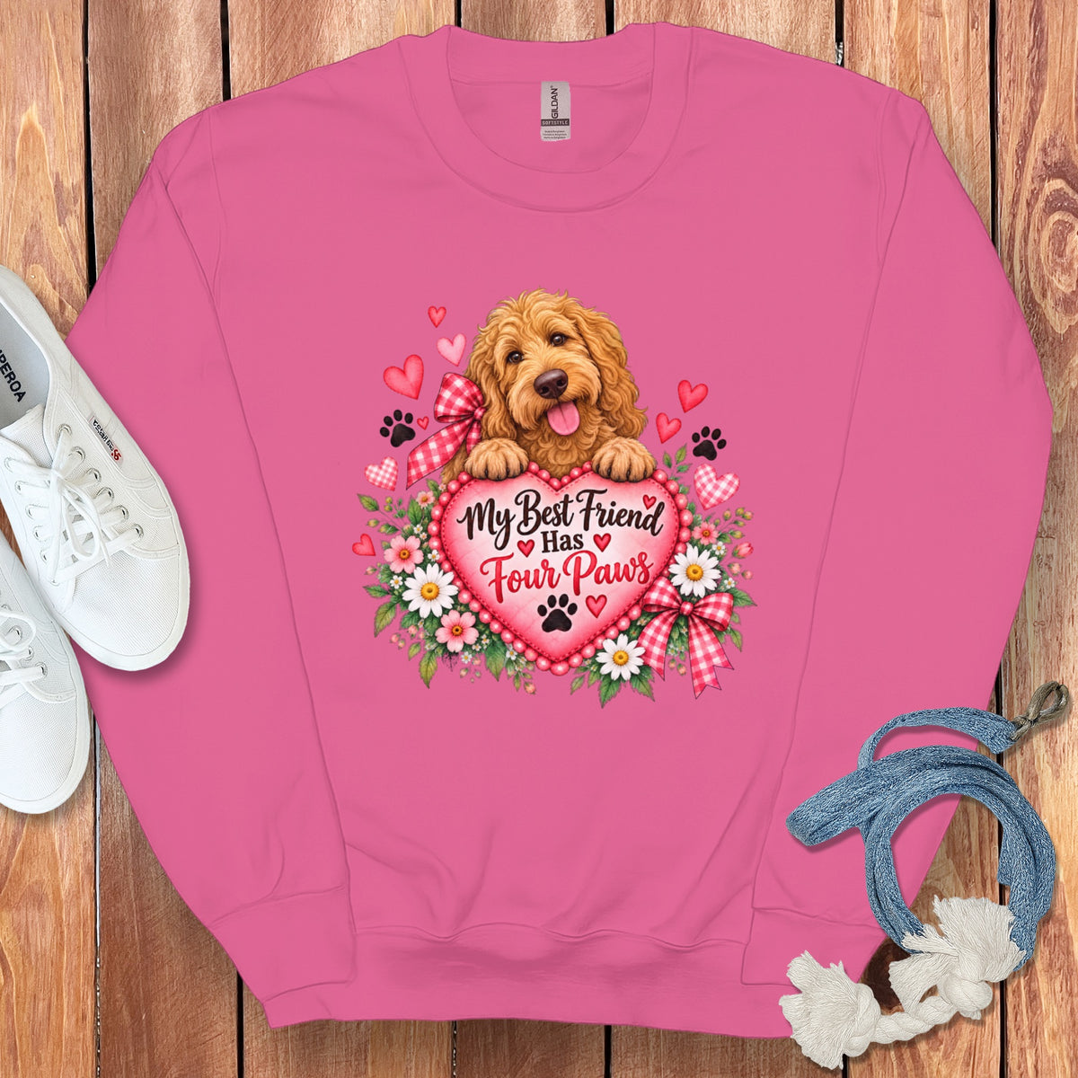 Pink crewneck sweatshirt featuring a graphic of a golden doodle, hearts, flowers, and text reading My Best Friend Has Four Paws.