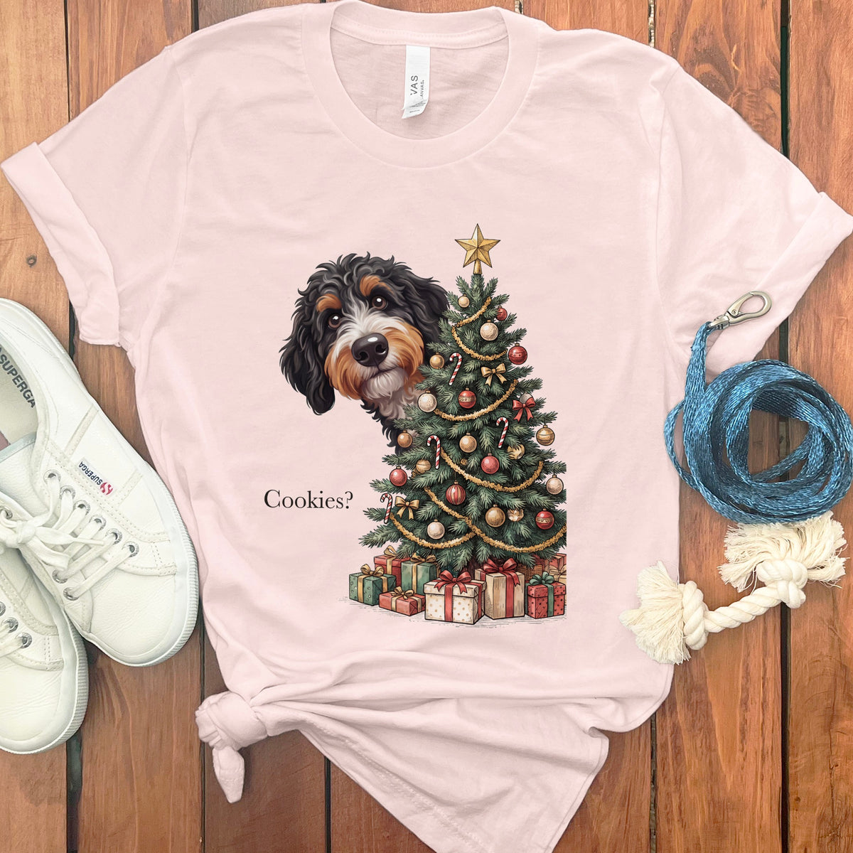 Bernese Mountain Dog peeks from behind Christmas tree asking "Cookies?".