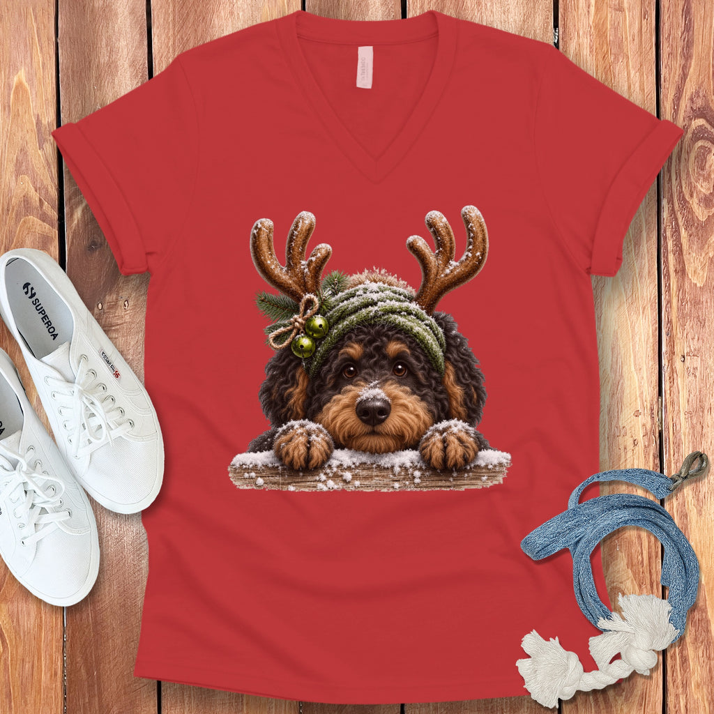 Red v-neck shirt with a fluffy dog wearing reindeer antlers and a Santa hat.