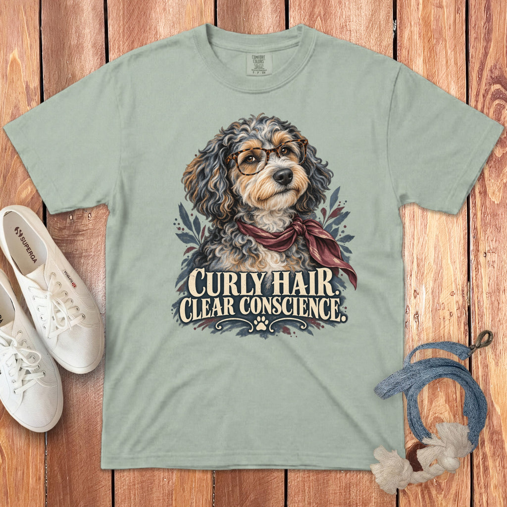 A sage green crewneck t-shirt featuring a doodle dog wearing glasses and the text Curly Hair, Clear Conscience.