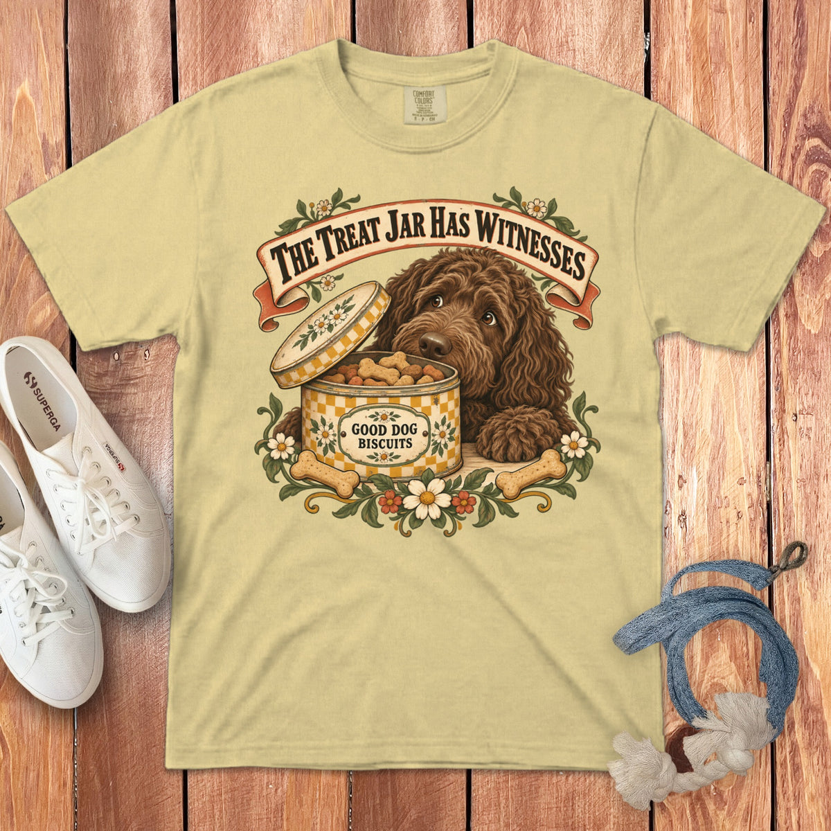A yellow crewneck t-shirt featuring a retro graphic of a brown dog beside an open biscuit tin.