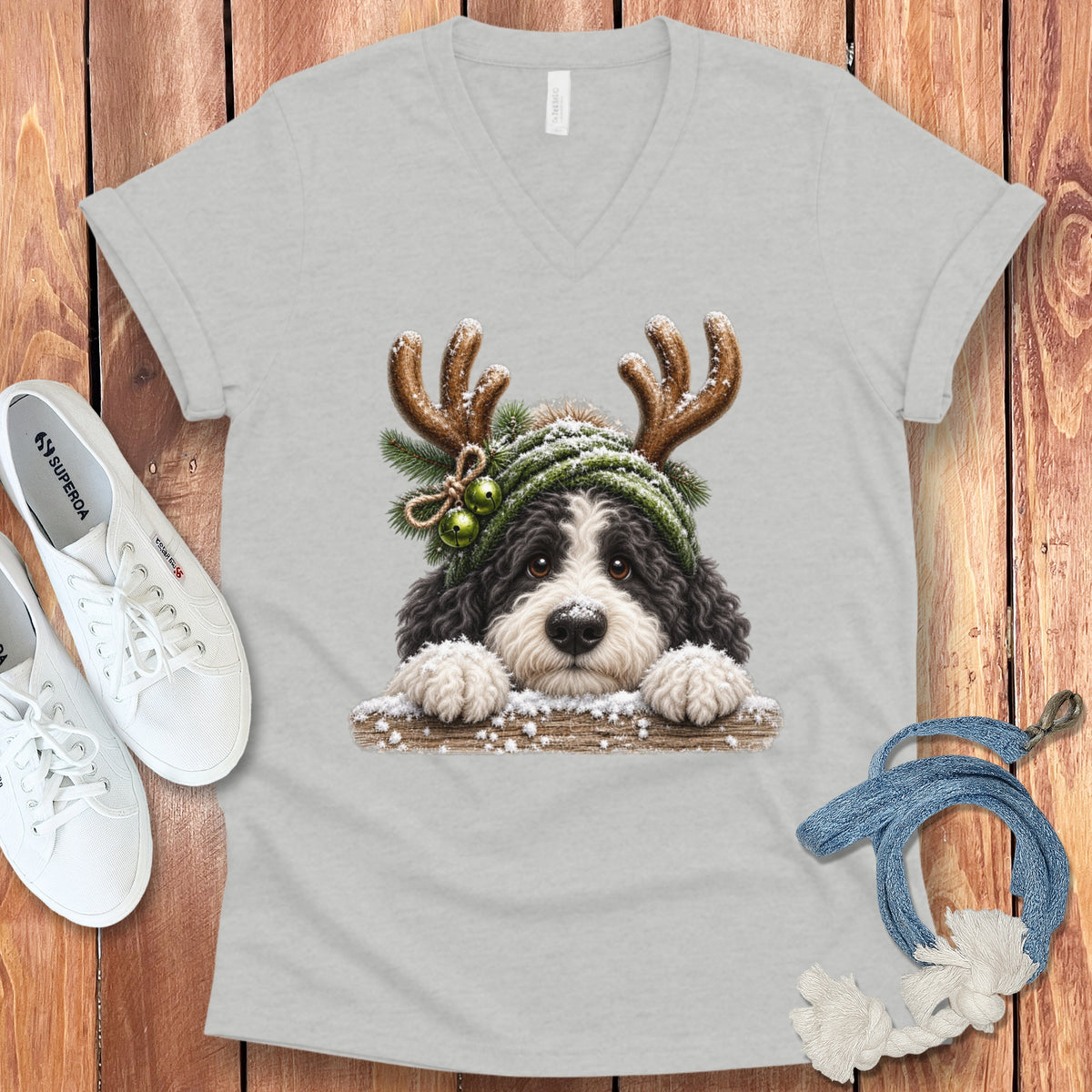 Bernedoodle puppy with reindeer antlers and green beanie, winter theme.