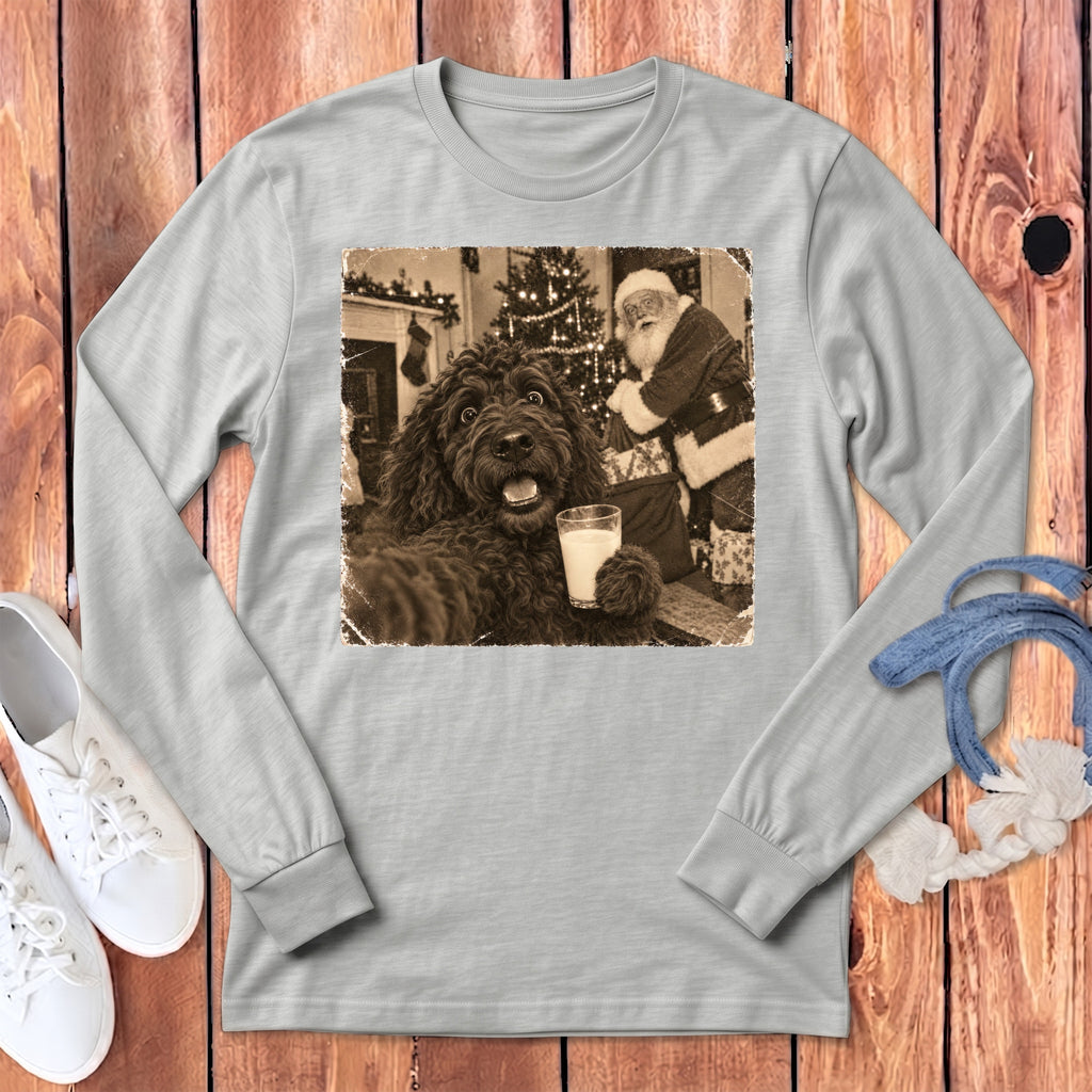 A light gray long-sleeve t-shirt features a vintage sepia-toned graphic of a fluffy dog holding a glass of milk with Santa Claus in the background.