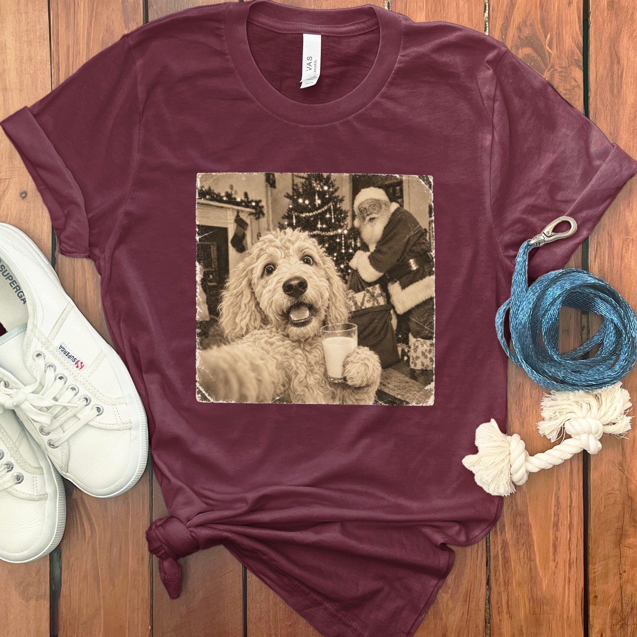 Maroon crewneck t-shirt featuring a vintage graphic of a fluffy dog holding a glass of milk with Santa Claus in the background.
