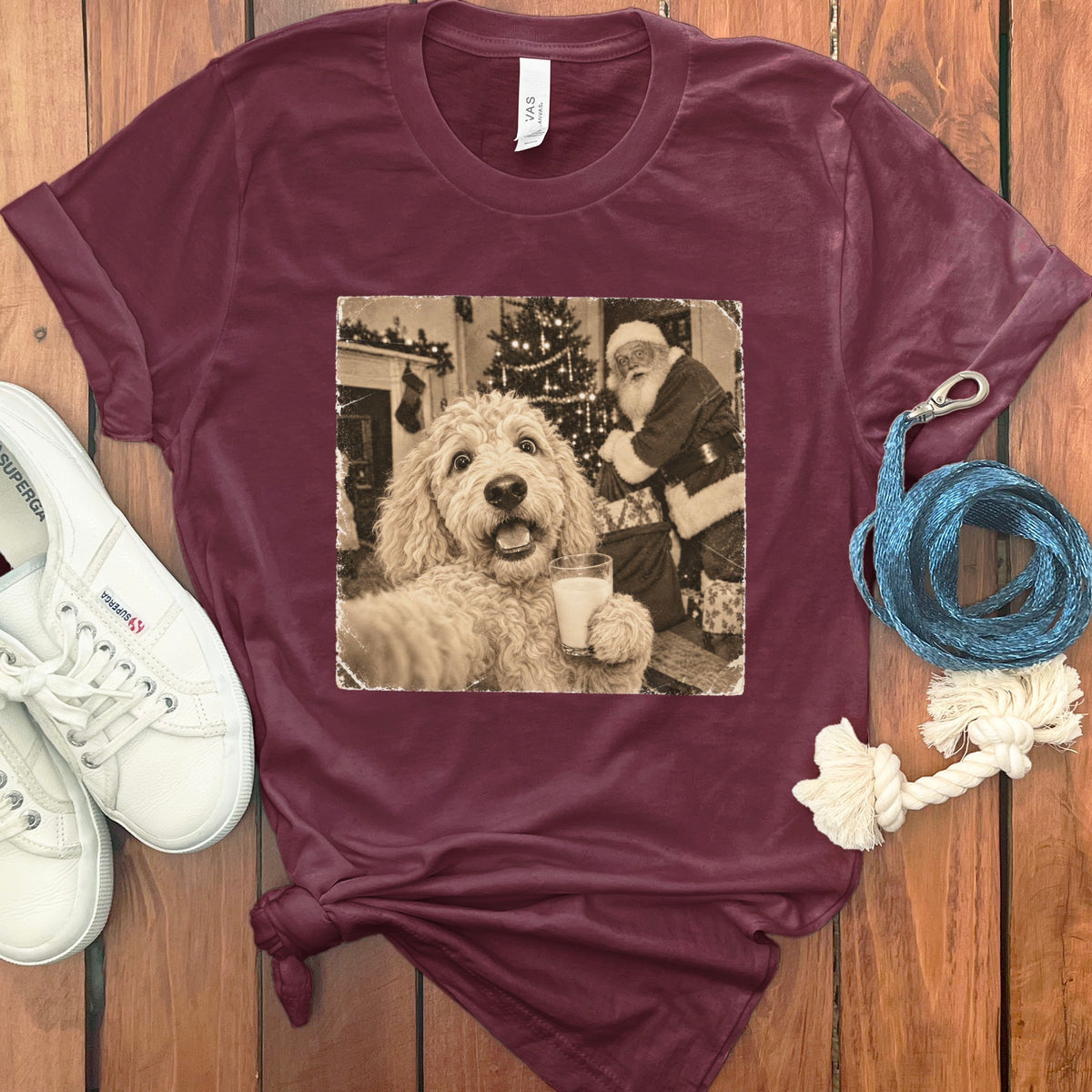 Maroon crewneck t-shirt featuring a vintage graphic of a fluffy dog holding a glass of milk with Santa Claus in the background.