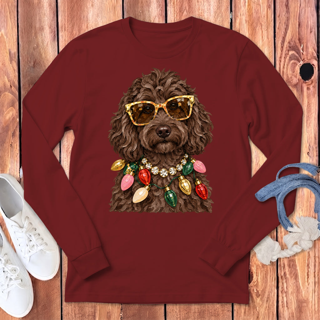 Brown poodle wearing sunglasses and a Christmas light necklace on a maroon shirt.