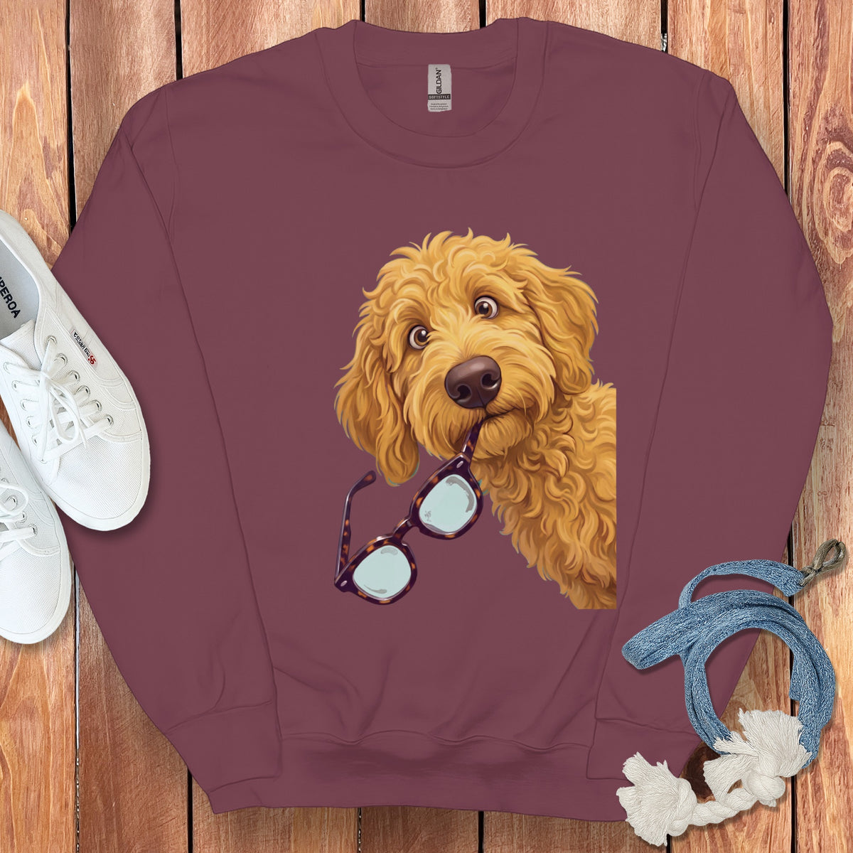 Maroon crewneck sweatshirt featuring a graphic of a golden fluffy dog holding glasses in its mouth.
