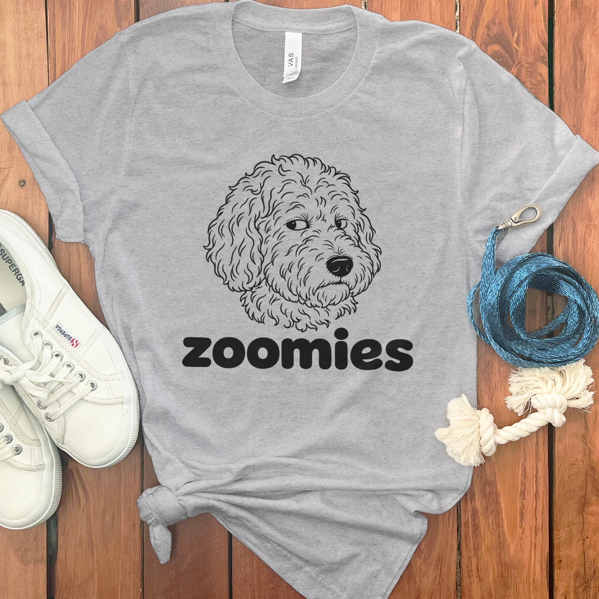 Grey t-shirt with a doodle dog face graphic and the word "zoomies".