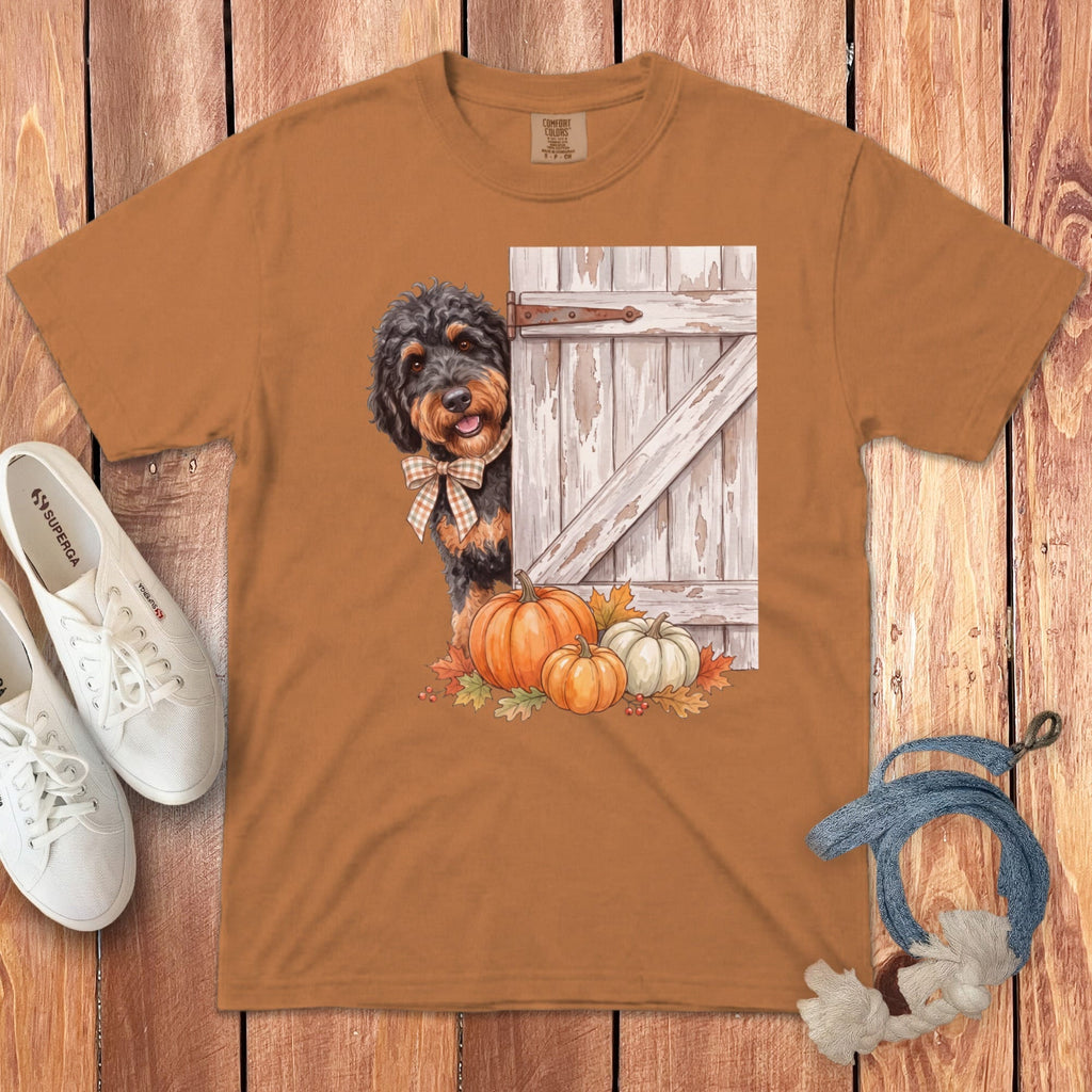 Brown t-shirt with a dog peeking from behind a barn door with pumpkins.