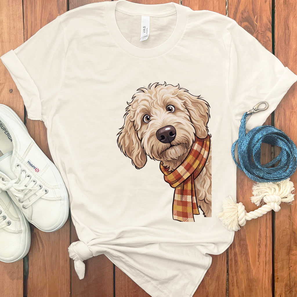 Cream t-shirt with illustration of a fluffy dog wearing a plaid scarf.