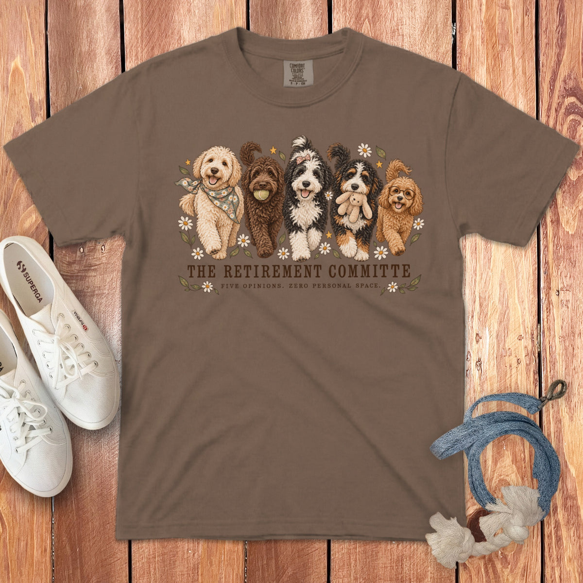 Brown t-shirt featuring a cartoon of five dogs and text that reads The Retirement Committee.