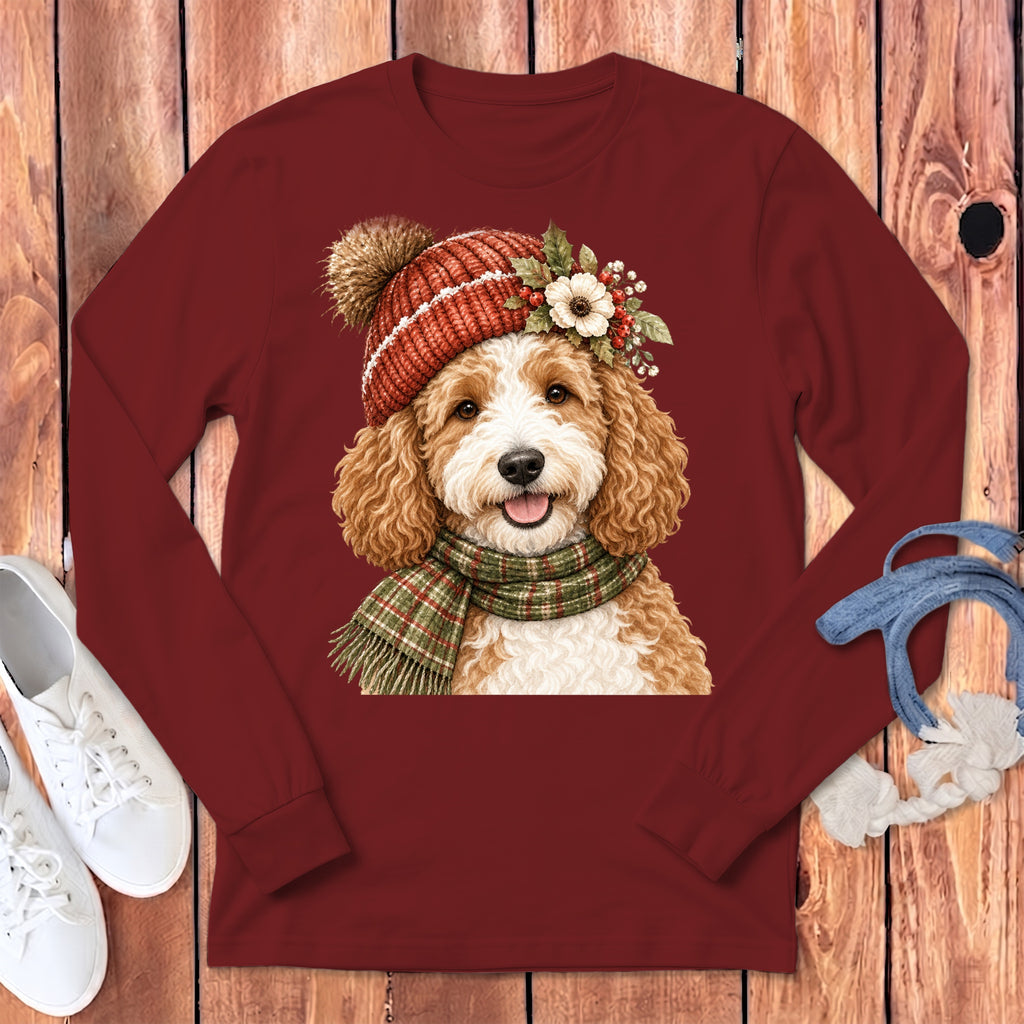 Doodle dog wearing a Christmas hat and scarf, on a maroon long-sleeve shirt.